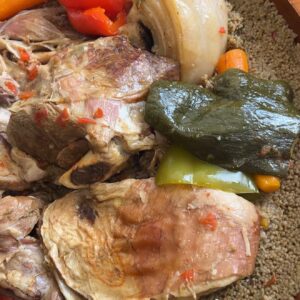 Couscous mauritanien : semoule fine, agneau, poulet, carottes, poivrons et oignons servis dans un plat en bois