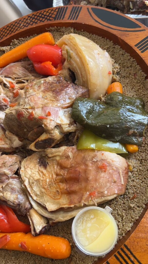Couscous mauritanien : semoule fine, agneau, poulet, carottes, poivrons et oignons servis dans un plat en bois